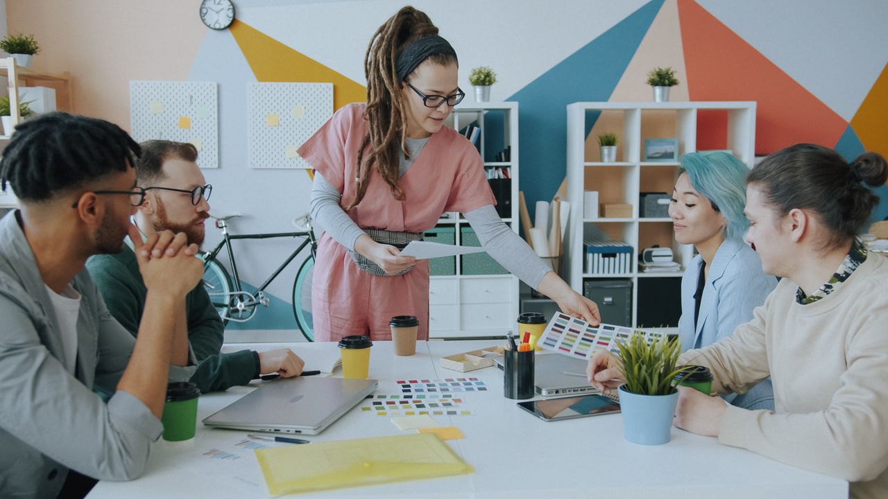Services Team of professionals discussing color samples in a modern, vibrant office space.